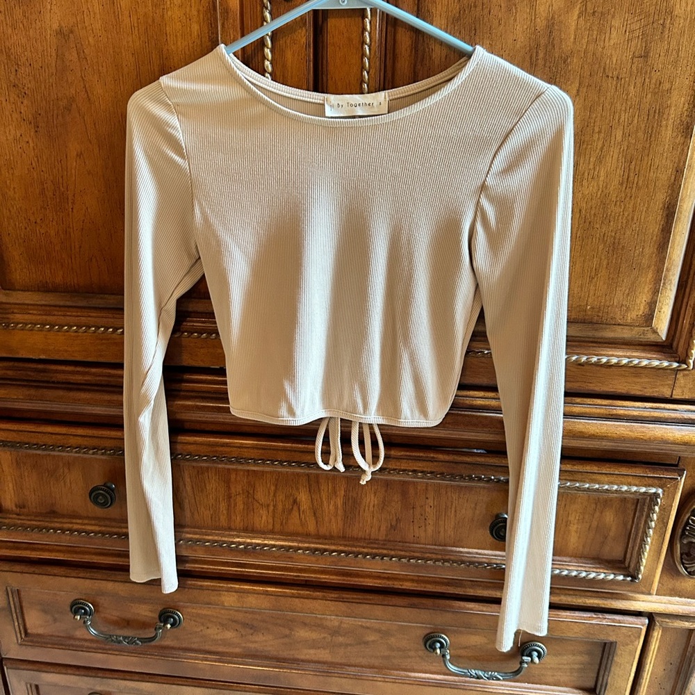 Cream long sleeve crop top with open back.
